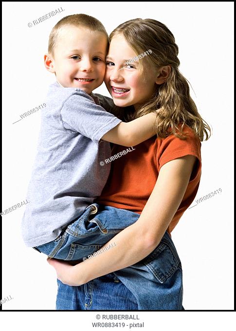 Portrait of a sister carrying her brother and smiling