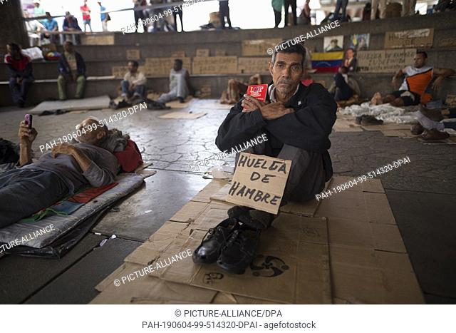 04 June 2019, Venezuela, Caracas: ""Hunger strike"", is written on cardboard by Humberto Cifontes, a former oil worker who draws attention to himself with...