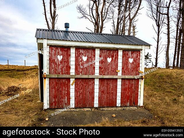 Outhouse toilet with four closed and locked doors in rural area of Norway