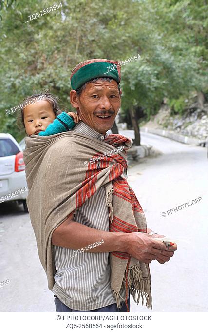 SPITI VALLEY - Grand Father carrying grand son in Gyu village Himachal Pradesh , India