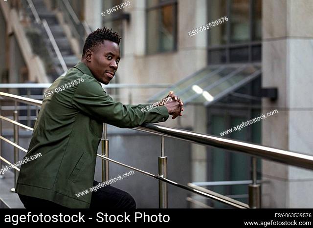 african-american man in stylish jacket on city street in the evening. copy space for text