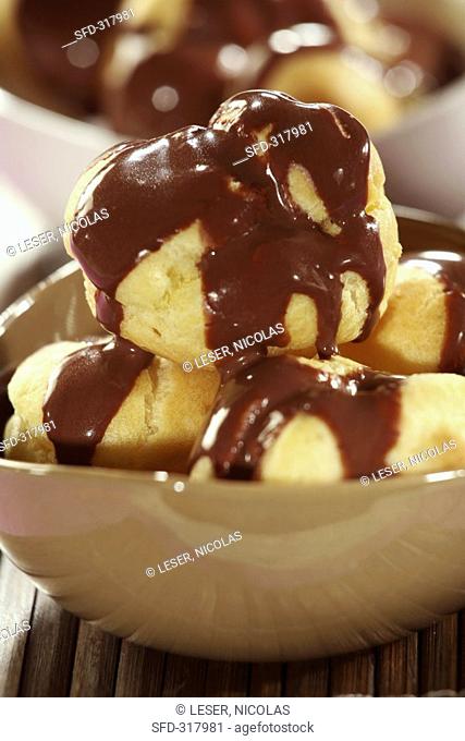 Profiteroles with chocolate sauce in a small bowl