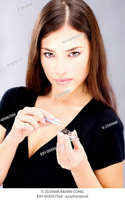 woman hold contact lenses cases and lens