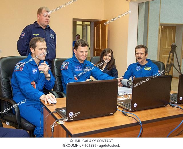 At their Cosmonaut Hotel crew quarters in Baikonur, Kazakhstan, the Expedition 34 crew practices docking simulations on a laptop computer Dec