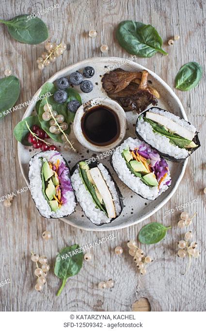 Onigirazu (Japanese sushi sandwich) - seaweed (nori), sushi rice, pickles vegetable, avocado and wasabi