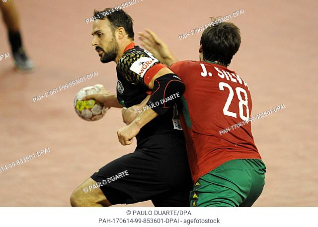 GermanyÂ·s Tim Kneule, left, challenges for the ball with PortugalÂ·s Jorge Silva during the Euro 2018 Qualification Group 5 handball match between Portugal and...