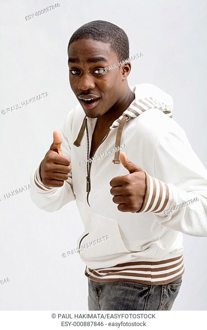 Dark skinned handsome young man, stylish wearing a white hooded shirt, Everything is okay, two thumbs up! Isolated