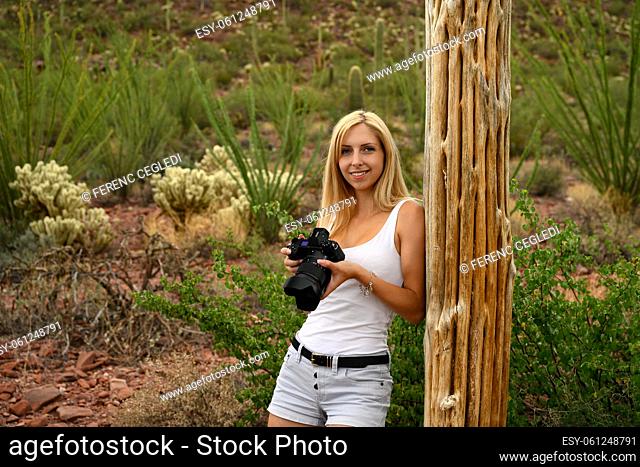 Female nature lover photographing the saguaro cactus (Carnegiea gigantea) with her professional camera in Saguaro National Park, Arizona, USA