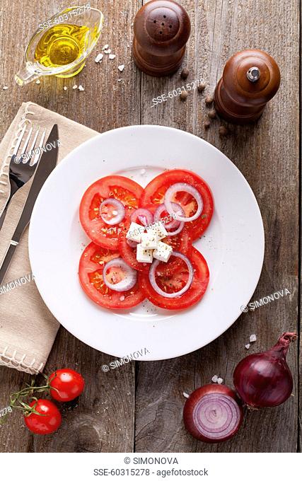 Thinly sliced tomatoes with red onions and feta