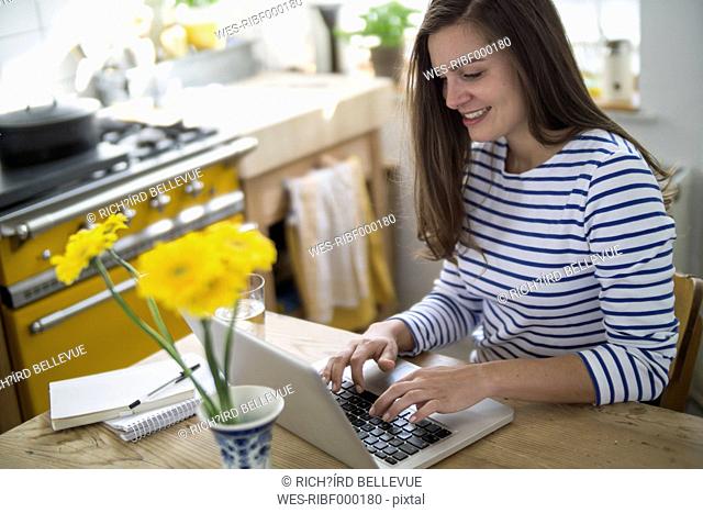 Young woman using laptop, working from home