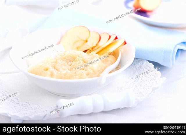 Apple puree dessert with cream and fresh apples in a white bowl on a white tea-tray. selective focus