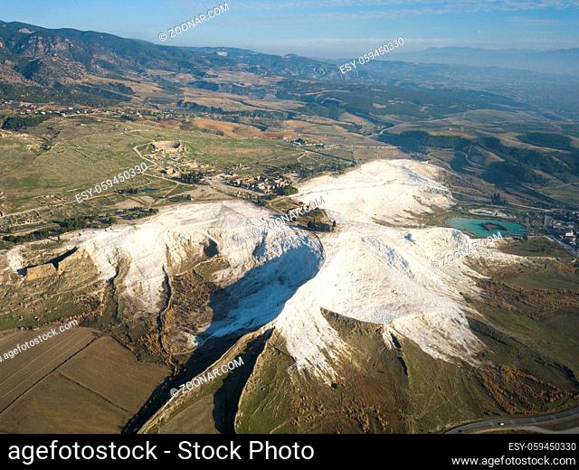 Aerial drone view of Hierapolis Roman ruins and white travertine terraces from high angle overview in Pamukkale, Turkey