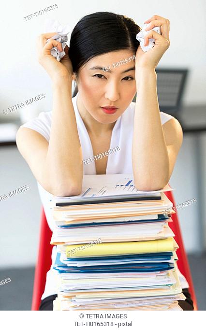 Portrait of businesswoman with stack of files