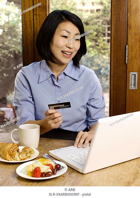 Businesswoman eating and shopping online