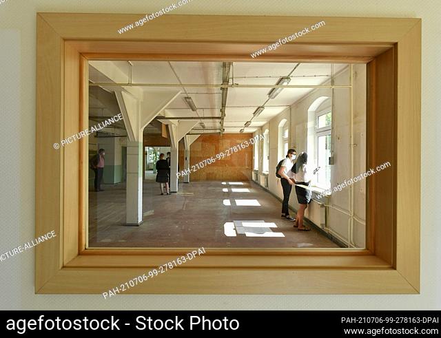 06 July 2021, Thuringia, Kloster Veßra: Participants at a press event inspect a depot building for two museums in Kloster Veßra (shot through a window built...