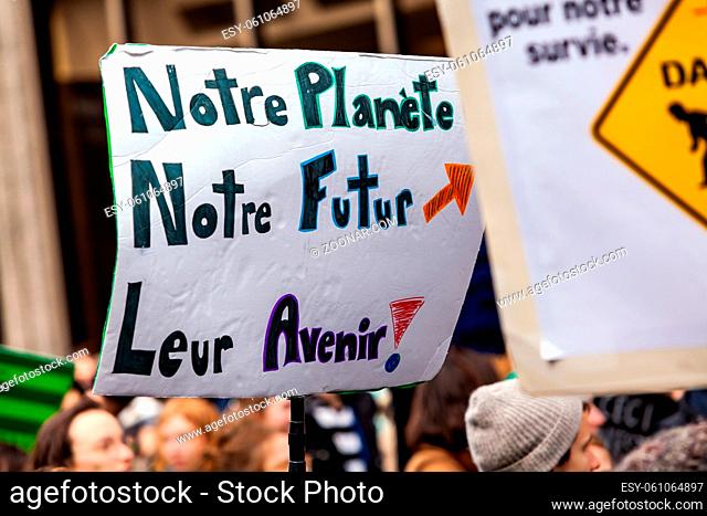 A French placard is viewed up close, saying our planet, our future, their future, as environmentalists stage a demonstration in a city center