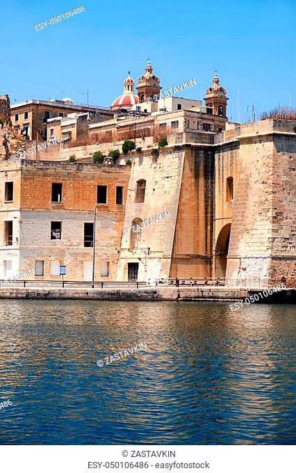 The view of historical buildings of Senglea city with Sheer Bastion and Isla Basilica over the Dockyard creek from Birgu. Malta