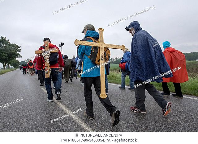 17 May 2018, Germany, Niedertraubling: Pilgrims carrying wooden crosses on their back. The pilgrims are set to walk 111 kilometres from Regensburg to Altoetting...