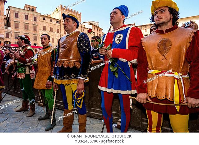 Representatives In Medieval Costume From Each Contrada Await The Tratta (The allocation of the horses) Ceremony, The Palio, Siena, Tuscany, Italy