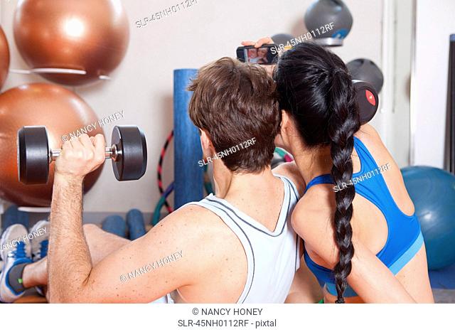 Couple taking picture together in gym