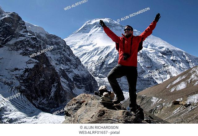 Mountaineer cheering on top of French Pass, Dhaulagiri Circuit Trek, Himalaya, Nepal