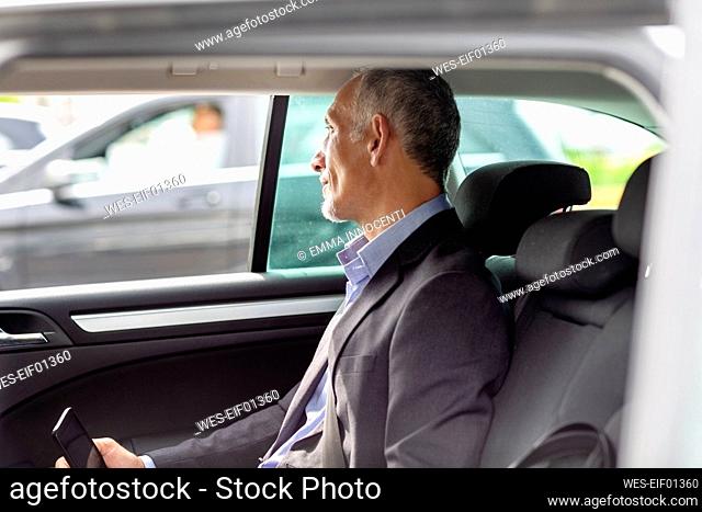 Male professional looking through window while sitting in car