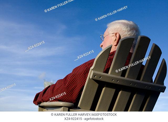 older man gazes into blue sky
