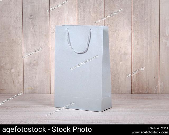 Paper shopping bag on wooden table