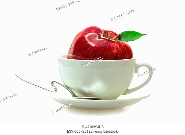 apple in a cup and spoon isolated on white