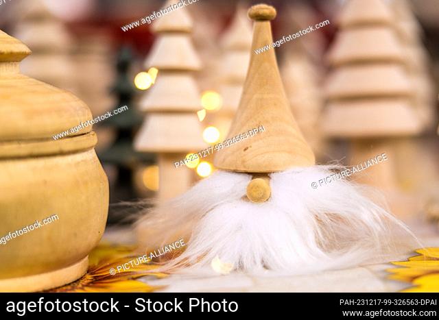 16 December 2023, Brandenburg, Leuthen: Wooden Christmas decorations on a stall at a small Advent market. Advent and Christmas markets are also held in many...