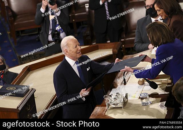 U.S. President Joe Biden hands a copy of his speech to Speaker of the House Nancy Pelosi in front of Vice President Kamala Harris as he arrives to deliver his...