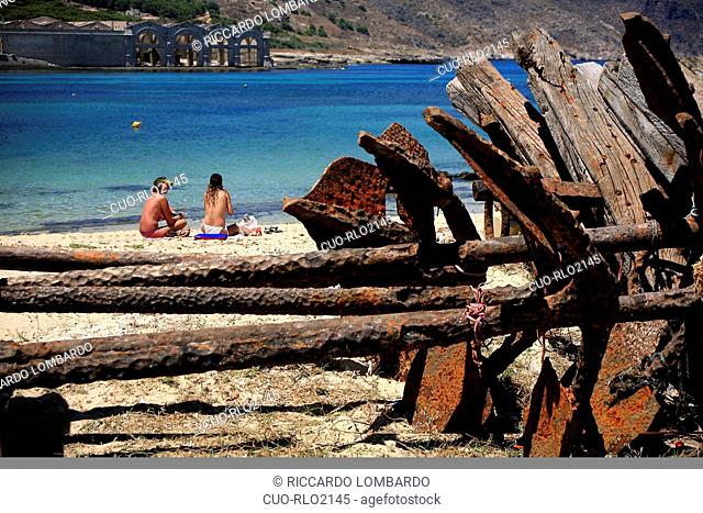Bathers and anchor, Favignana island, Aegadian Islands, Sicily, Italy