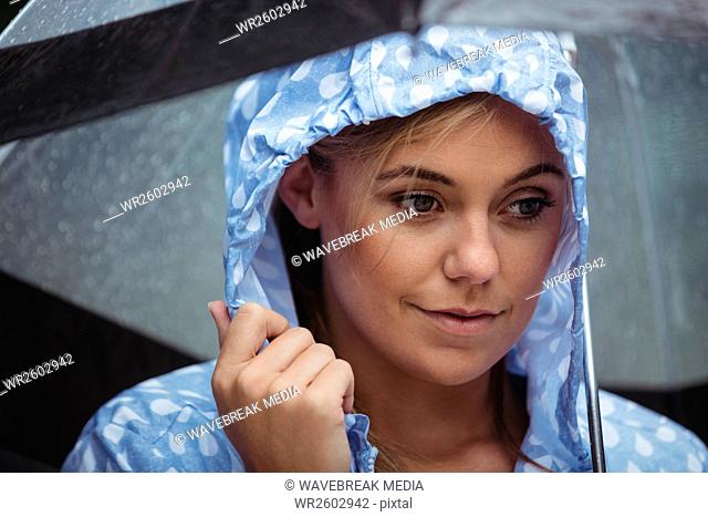 Thoughtful woman holding umbrella