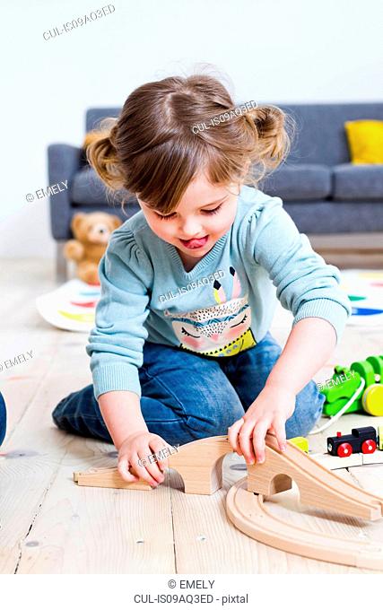 Girl playing with toy cars at home