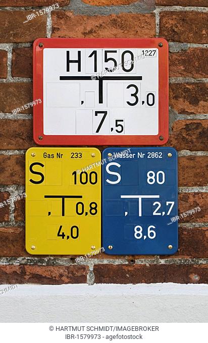 Different slider signs, fire-hydrant signs, gas and water, on brick wall