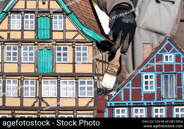 09 November 2022, Saxony, Lichtenstein: The model of a historic row of houses with the Kunsthaus (l) in Stade from 1667 is cleaned by Thomas Pfau in front of...