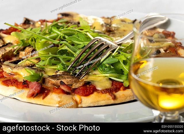 Pizza auf einem Teller mit Rucola