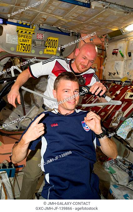 European Space Agency astronaut Alexander Gerst, Expedition 40 flight engineer, shaves the head of NASA astronaut Reid Wiseman, flight engineer