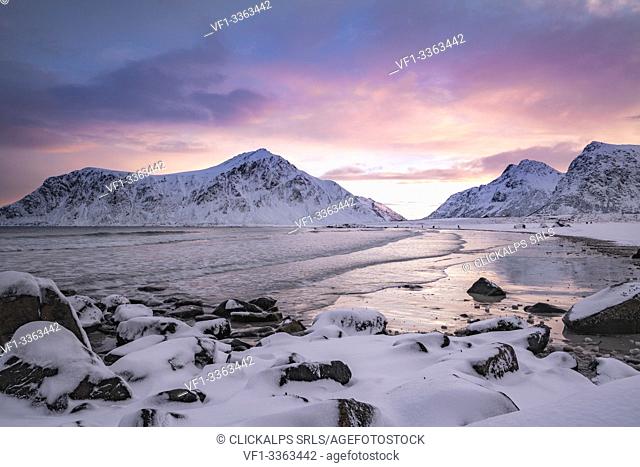 Skagsanden beach at dawn in winter, with rocks in the foreground. Flakstad, Nordland county, Northern Norway, Norway