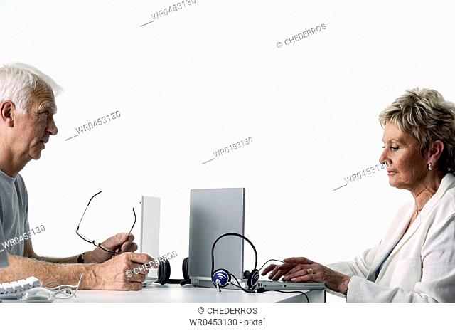 Side profile of a male customer service representative sitting with a female colleague
