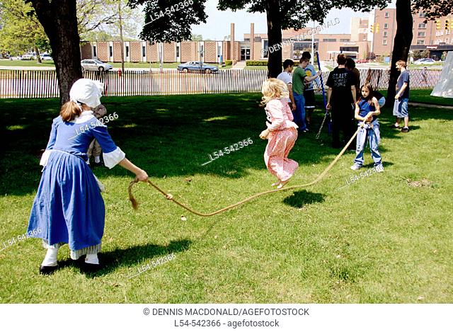 Children play jump rope Circa 1700 reenactment of the Colonial period lifestyle in Southeastern Michigan at the Feaste of Sainte Claire Port Huron Michigan