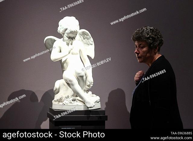 RUSSIA, MOSCOW - JUNE 5, 2023: A woman stands before a late 19th-century replica of Cupid by Etienne Maurice Falconet during an exhibition titled ""Salons by...