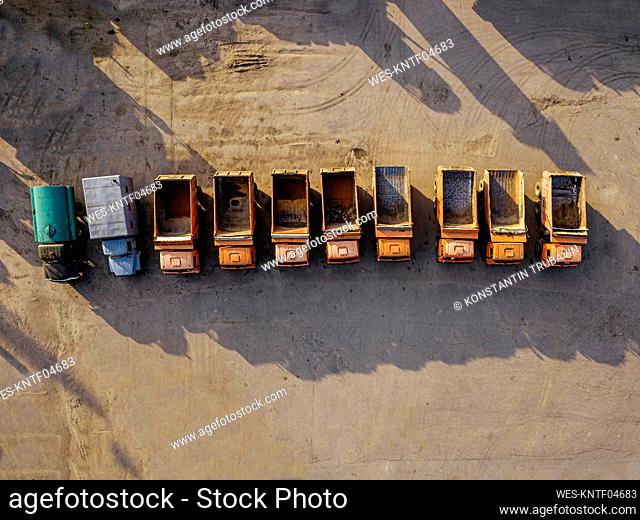 Aerial view of row of old empty trucks parked side by side