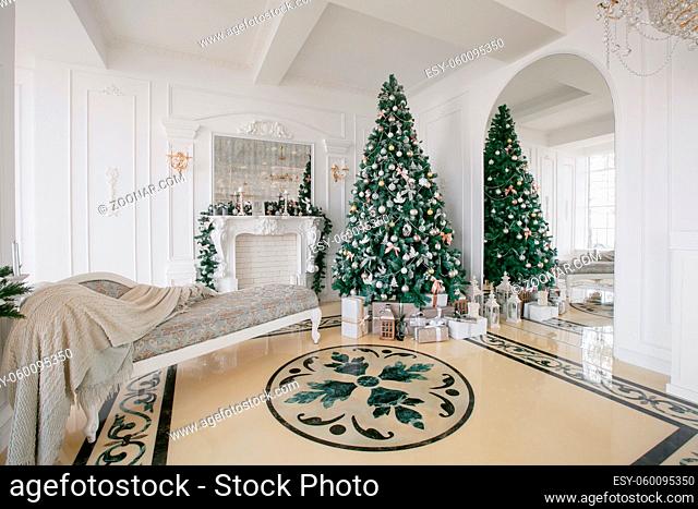 Christmas morning. classic apartments with a white fireplace, decorated Christmas tree, bright sofa, large windows