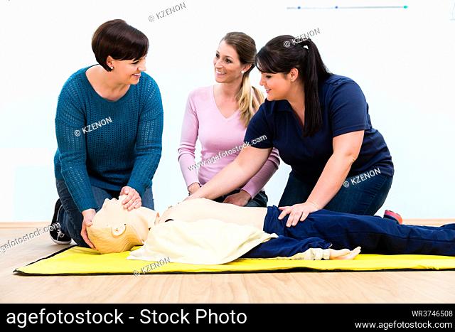Group of women in first aid course exercising life-sustaining measures