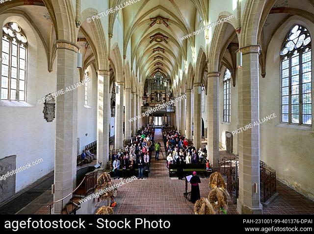 01 October 2023, Thuringia, Erfurt: Harvest crowns stand next to the altar in Erfurt's Predigerkirche. Thuringia celebrates the harvest festival with an...