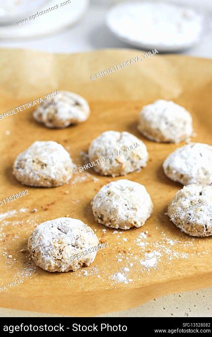 Pecan biscuits with icing sugar on baking paper
