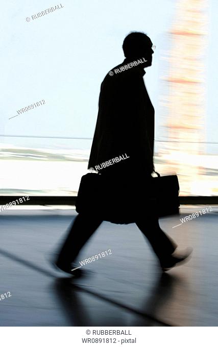 Silhouette of a businessman walking with a briefcase