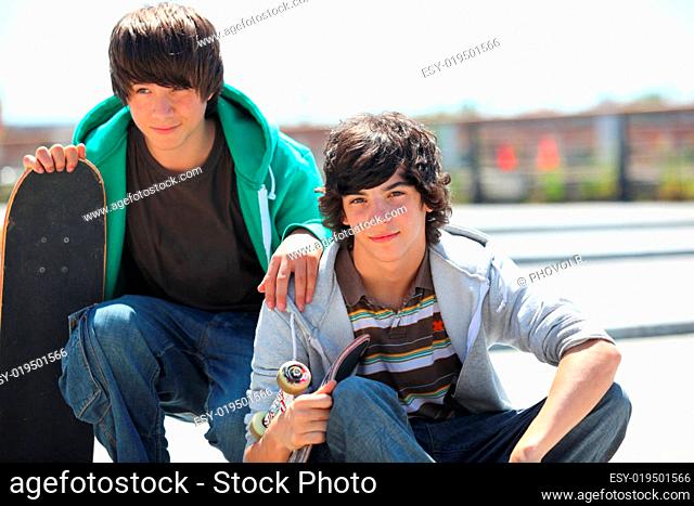 Portrait of two boys smiling with a skateboard