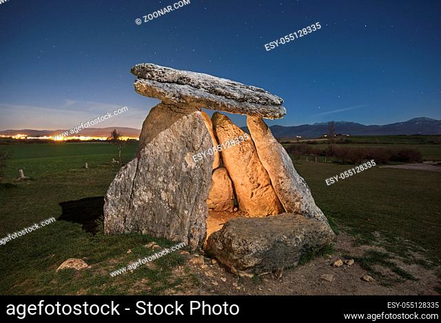 Prehistoric megalithic dolmen at night in the north of Spain, starry night in the background